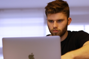 Young man on laptop apprentice